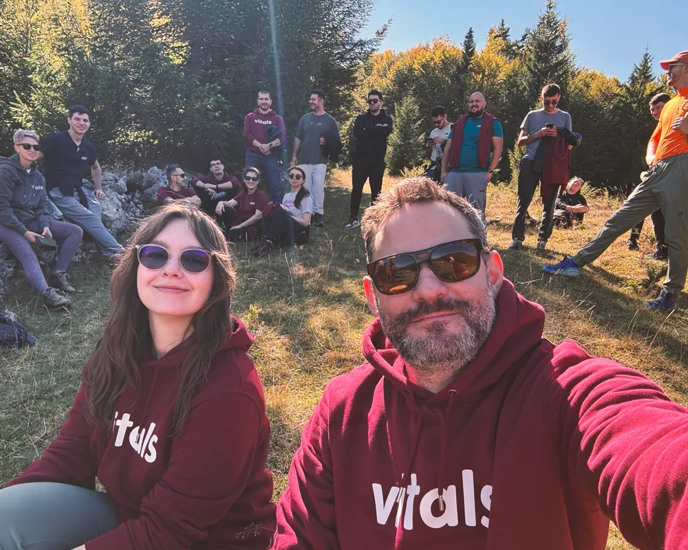 Two teammates in Vitals hoodies taking a selfie outdoors