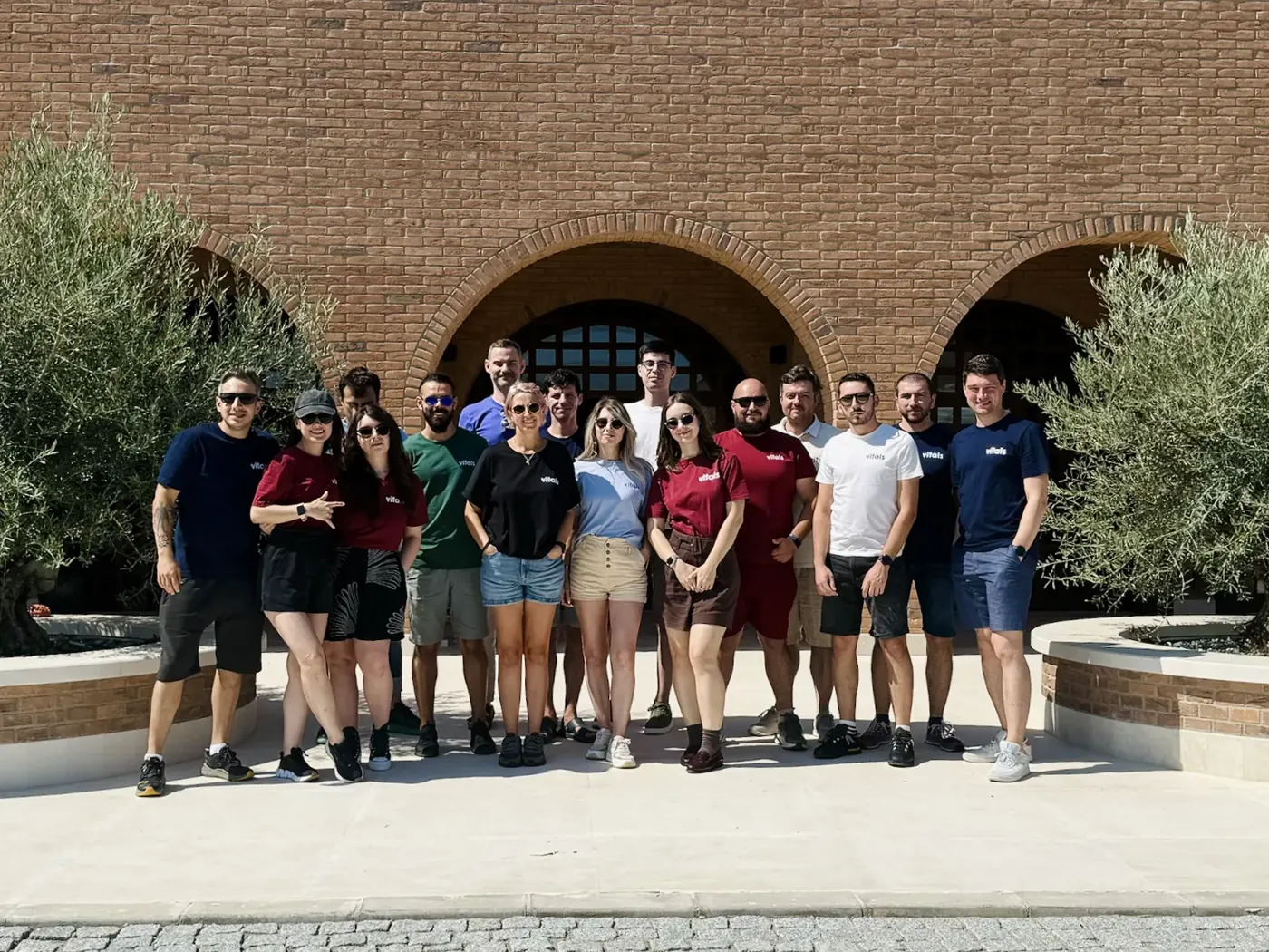 The Vitals team in front of a brick courtyard